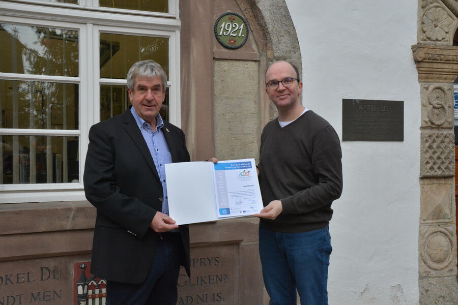 Bürgermeister Hermann Temme und Andreas Oesselke, Abteilungsleiter Organisation, halten die Urkunde der rezertifizierung zum Familienfreundlichen Unternehmen in den Händen
