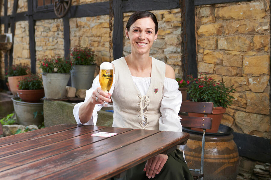 Symbolfigur Anneken mit einem Glas heimischen Bieres in der Hand in einer gemütlichen Brakeler Gastronomie
