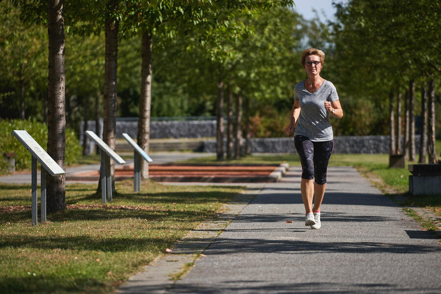 Sportliche Frau läuft im Generationenpark Lütkerlinde