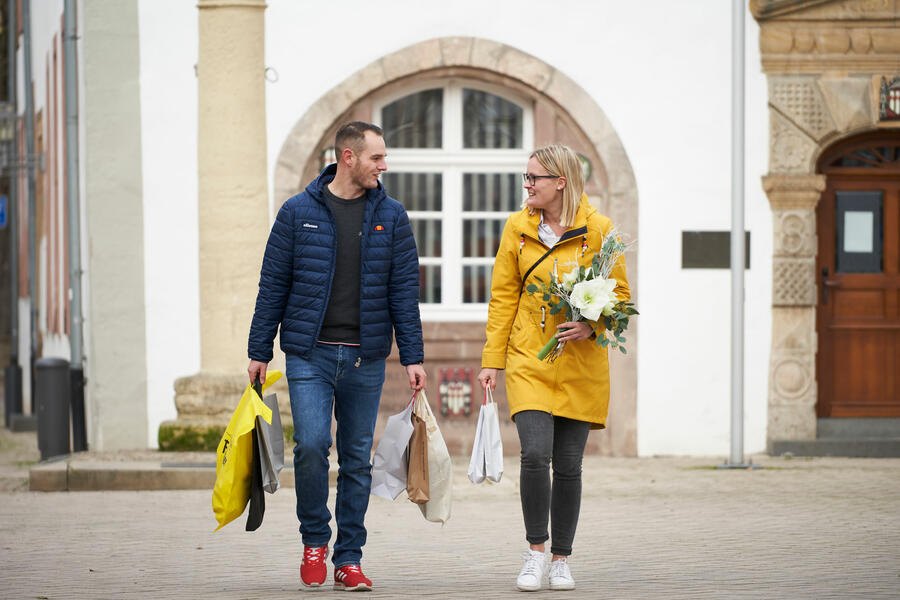 Junges Paar mit Einkaufstaschen der Brakeler Fachgeschäfte vor dem historischen Rathaus