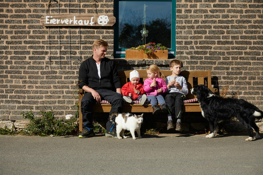 Familie vor einem Brakeler Hofladen auf einer Bank sitzend