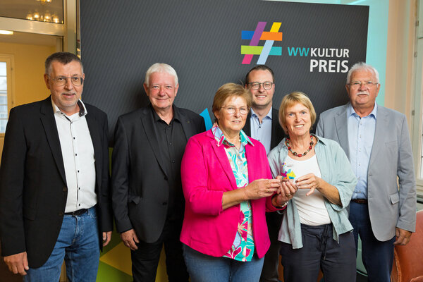 Preisverleihung WWKulturpreis 2025 in Minden (von links): R&uuml;diger H&ouml;lscher (Westfalen Weser), Andreas Lehnert (musikalische Leitung), Brigitte Backhaus, Anke Hupe-Keil und Franz-Josef Backhaus vom Kinderchor-Team. Es gratulierte Alexander Kleinschmidt als Allgemeiner Vertreter des B&uuml;rgermeisters (vierter von links).
