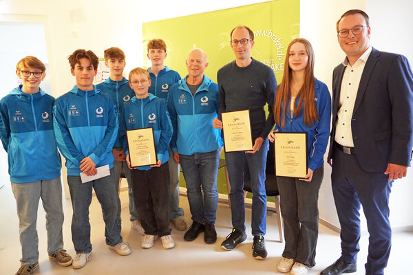 B&uuml;rgermeister Alexander Kleinschmidt (rechts) ehrte Stine Rogge als Sportlerin des Jahres, Sebastian Brandt (Mitte) als Sportler des Jahres und die Tischtennismannschaft der "Schulen der Brede" (von links: Til Roland, Phillipp Drewes, Felix Varju,  Mats Roland und Noah Oeynhausen) mit ihrem Trainer Bernd &Ouml;verm&uuml;hle als Mannschaft des Jahres 2025.