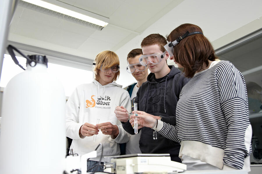Schülerinnen-und-Schüler-an-der-städtischen-Gesamtschule-Brakel tragen im Chemie-Unterricht Sicherheitsbrillen