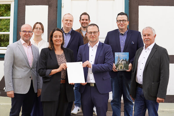 &Uuml;bergabe des F&ouml;rderbescheides f&uuml;r die Dachsanierung der &Ouml;sehalle in Siddessen: (von links) Andreas Oesselke (Allgemeiner Vertreter des B&uuml;rgermeisters), Louisa L&uuml;cke-Richter (Fachbereich Planen und Bauen), Regierungspr&auml;sidentin Anna Katharina B&ouml;lling, Peter Beller (Bezirksverwaltungsstellenleiter), Lucas Luedecke (Fachbereich Planen und Bauen), B&uuml;rgermeister Alexander Kleinschmidt, Bezirksausschussvorsitzender Stefan Heilemann sowie Axel L&uuml;dke, der Vorsitzende des Hallenbetreibervereins.