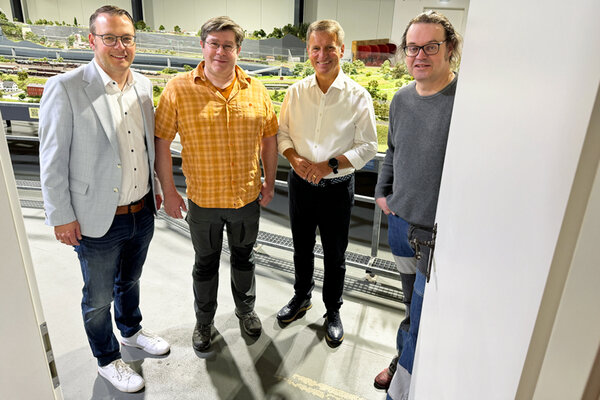 Die T&uuml;r zur Modellbundesbahn in Brakel wird sich wieder f&uuml;r Besucherinnen und Besucher &ouml;ffnen, nachdem die Anlage nun umfassend erweitert werden kann. Mit einer gemeinsamen Initiative haben Landrat Michael Stickeln (3.v.l.) und Brakels B&uuml;rgermeister Alexander Kleinschmidt (2.v.l.) einen wichtigen Impuls f&uuml;r die Rettung gegeben, indem sie in einem &ouml;ffentlichen Aufruf um Unterst&uuml;tzung f&uuml;r die einzigartige Anlage gebeten haben. Mit gro&szlig;er Freude und viel Tatendrang blicken die Betreiber Karl Fischer (r.) und Norbert Sickmann nun in die Zukunft.