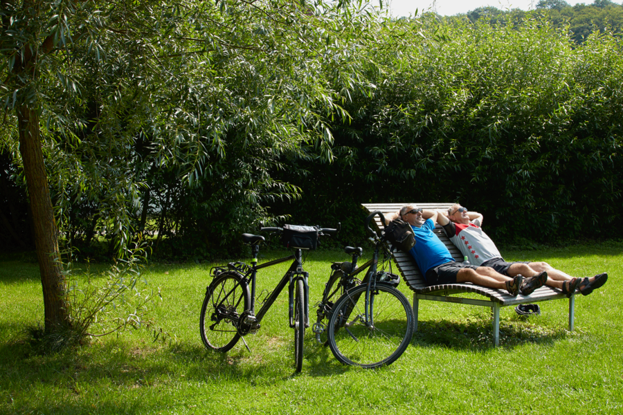 Radfahrer machen eine Pause auf einer Ruhebank
