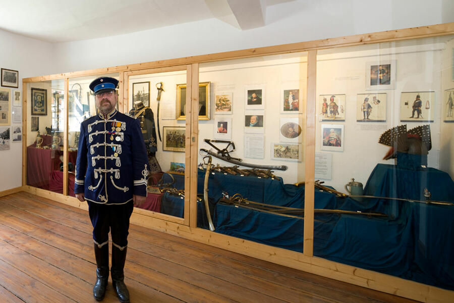 Husar in histoorischer Uniform vor den Exponaten im Husarenmuseum in Rheder