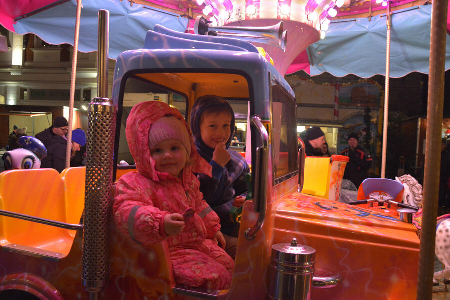 Zwei glückliche Kinder sitzen im Kinderkarussell-auf-dem-Brakeler-Nikolausmarkt