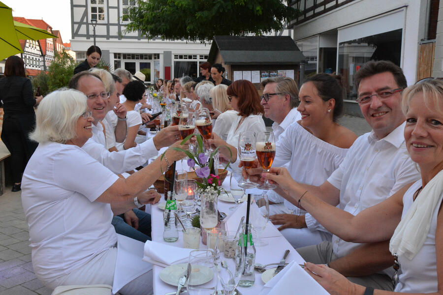 Weiß eingedeckte, lange Tafel auf dem Brakeler Marktplatz beim Dinner-in-white-am-Stadtstrand, zu Gast sind ausschließlich weiß gekleidete Gäste